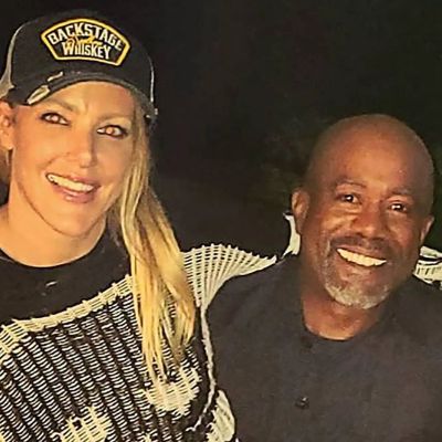 She has her arms around him as they are taking the selfie.